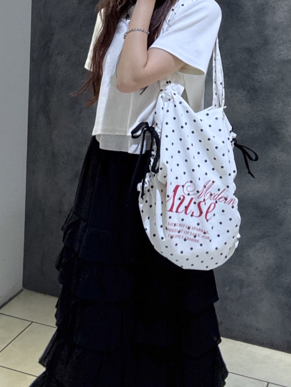 ホワイト系のTシャツ/カットソー、ブラック系のスカート、ブラック系のサンダルを着用したレディースの夏コーディネートの6枚目の写真