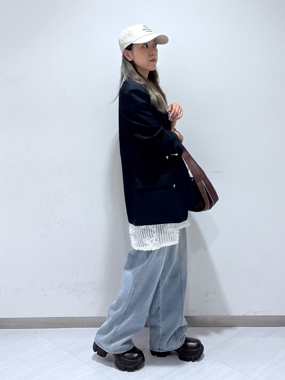 ブルー系のテーラードジャケット、ホワイト系のワンピース、ブルー系のデニムパンツを着用したレディースの夏コーディネートの3枚目の写真