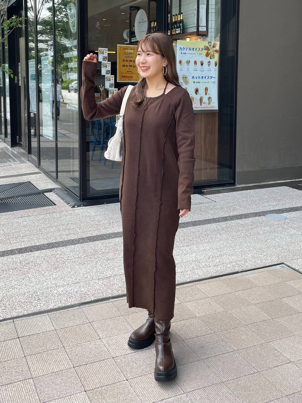 ブラウン系のブーツ、ホワイト系のショルダーバッグ、ブラウン系のワンピースを着用したレディースの秋コーディネートの2枚目の写真