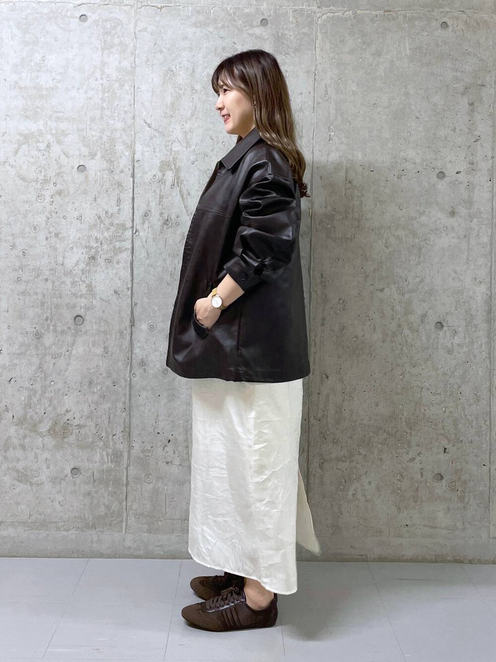 ブラウン系のスニーカー、ブラウン系のブルゾン、ホワイト系のワンピースを着用したレディースの冬コーディネートの2枚目の写真