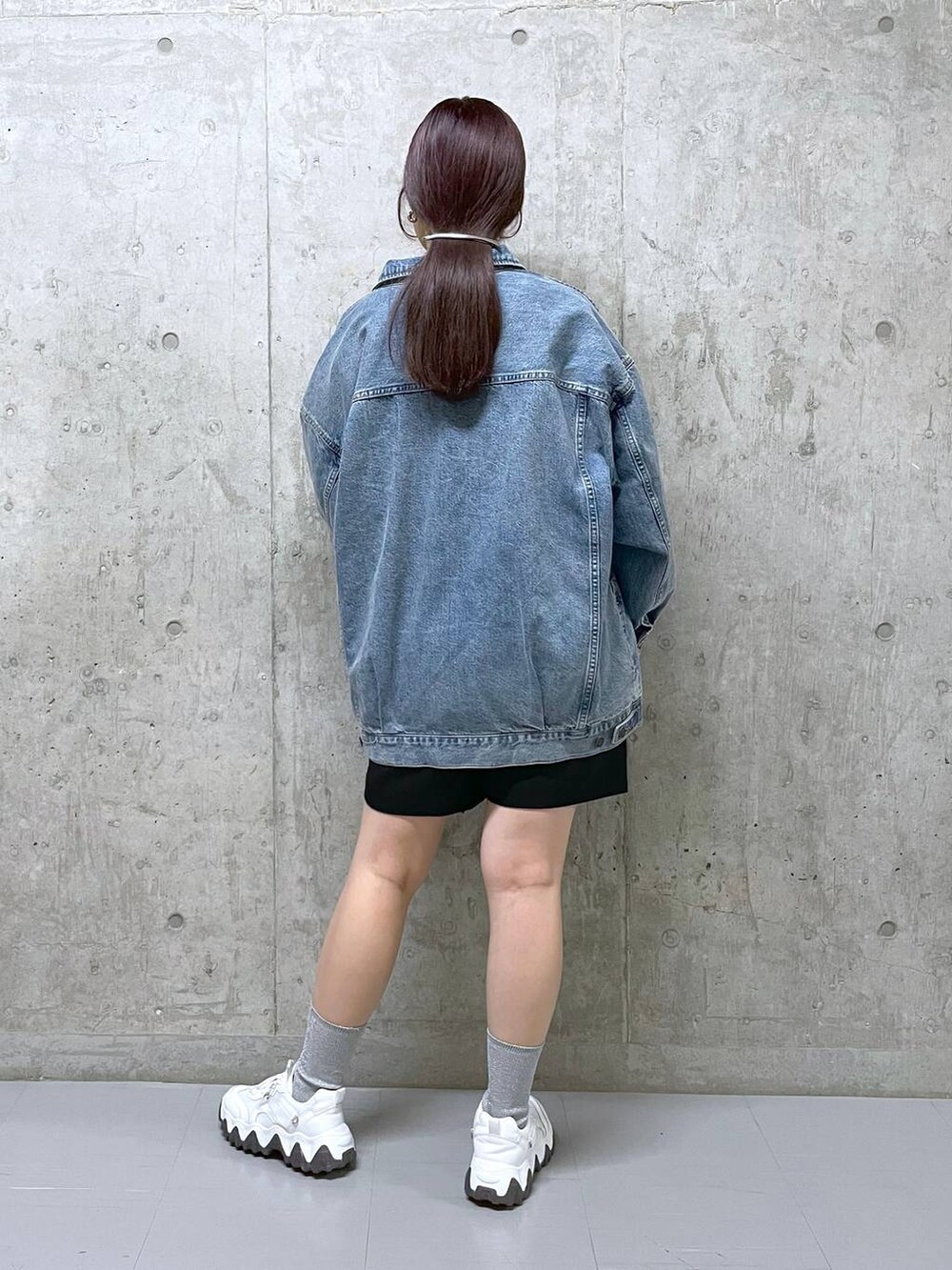 ブラック系のその他パンツ、ブルー系のデニムジャケット、グレー系のニット/セーターを着用したレディースの春コーディネートの3枚目の写真