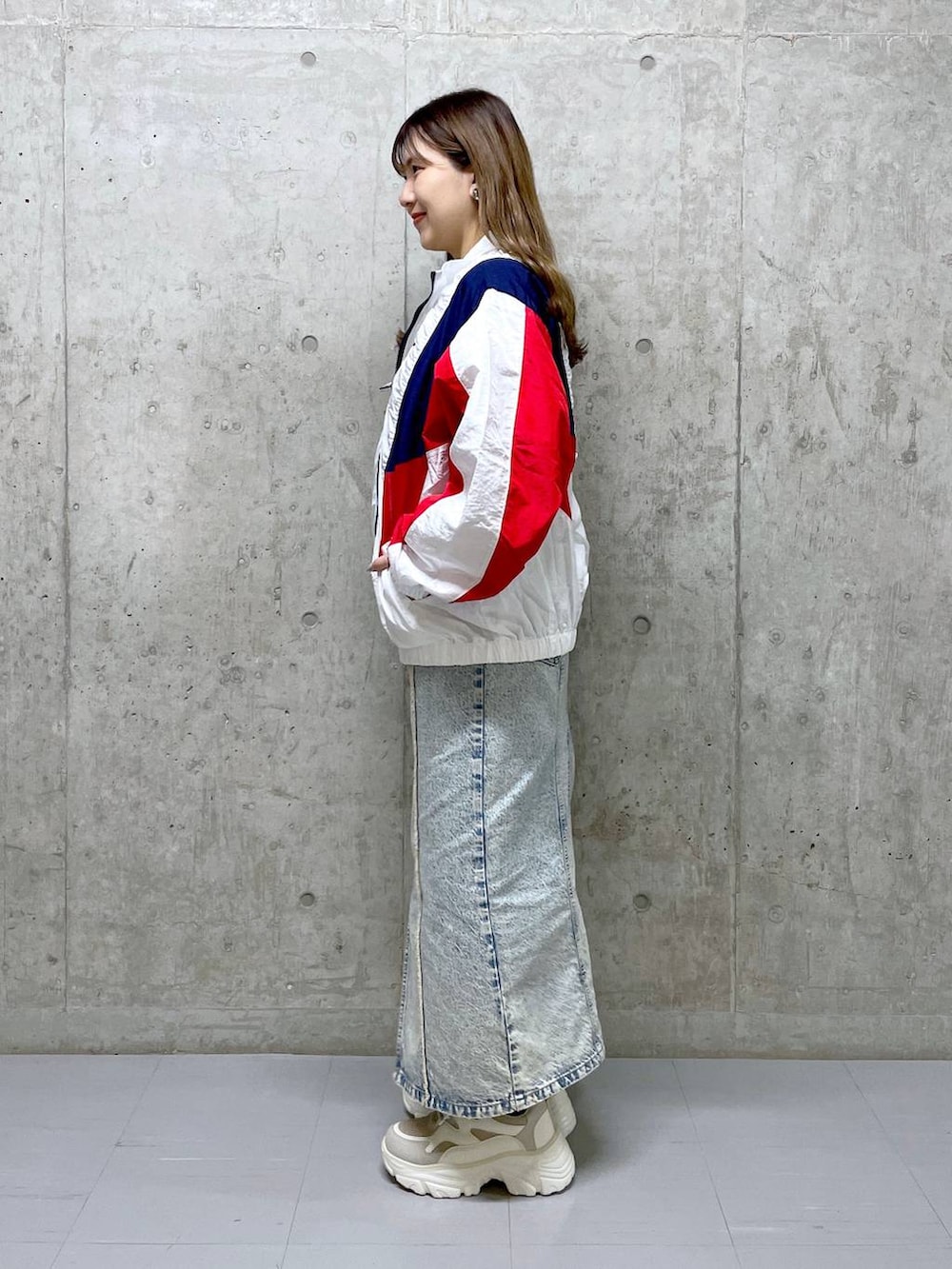 ブルー系のジャンパースカート、グレー系のTシャツ/カットソー、ベージュ系のスニーカーを着用したレディースの冬コーディネートの2枚目の写真