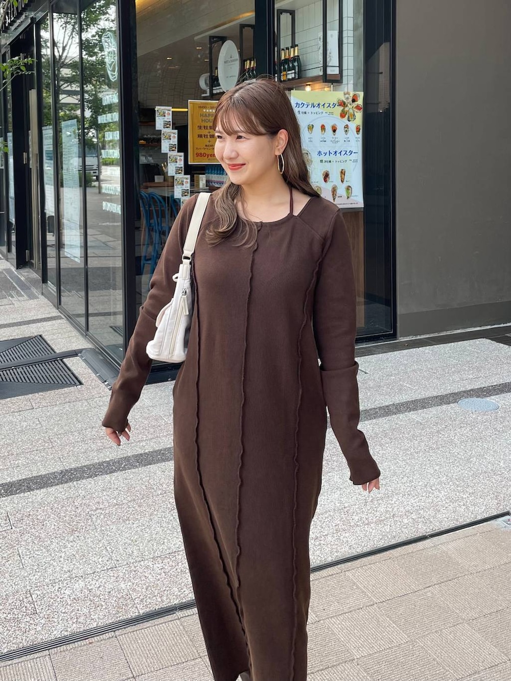 ブラウン系のブーツ、ホワイト系のショルダーバッグ、ブラウン系のワンピースを着用したレディースの秋コーディネートの5枚目の写真