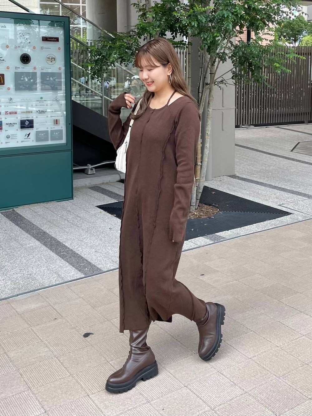 ブラウン系のブーツ、ホワイト系のショルダーバッグ、ブラウン系のワンピースを着用したレディースの秋コーディネートの3枚目の写真