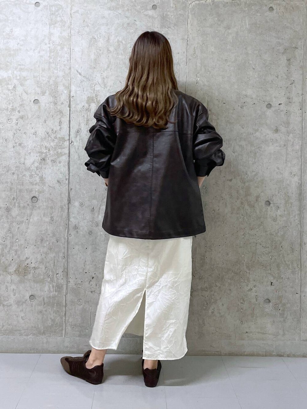 ブラウン系のスニーカー、ブラウン系のブルゾン、ホワイト系のワンピースを着用したレディースの冬コーディネートの3枚目の写真