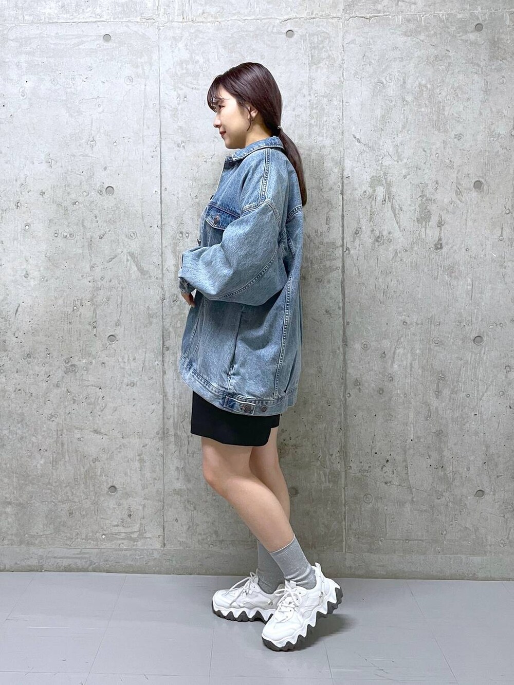 ブラック系のその他パンツ、ブルー系のデニムジャケット、グレー系のニット/セーターを着用したレディースの春コーディネートの2枚目の写真