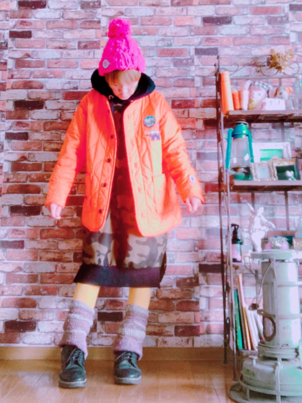 オレンジ系のその他アウター、グリーン系のワンピース、ブラック系のブーツを着用したレディースの冬コーディネートの3枚目の写真