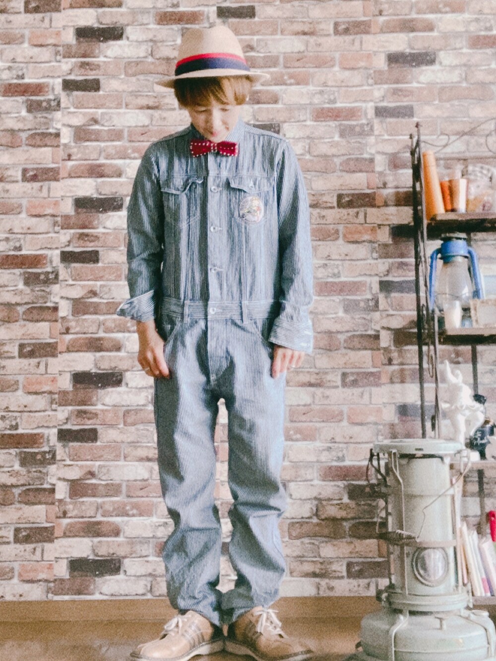 ブルー系のオールインワン・サロペット、レッド系の蝶ネクタイ、ベージュ系のシューズを着用したレディースの春コーディネートの2枚目の写真
