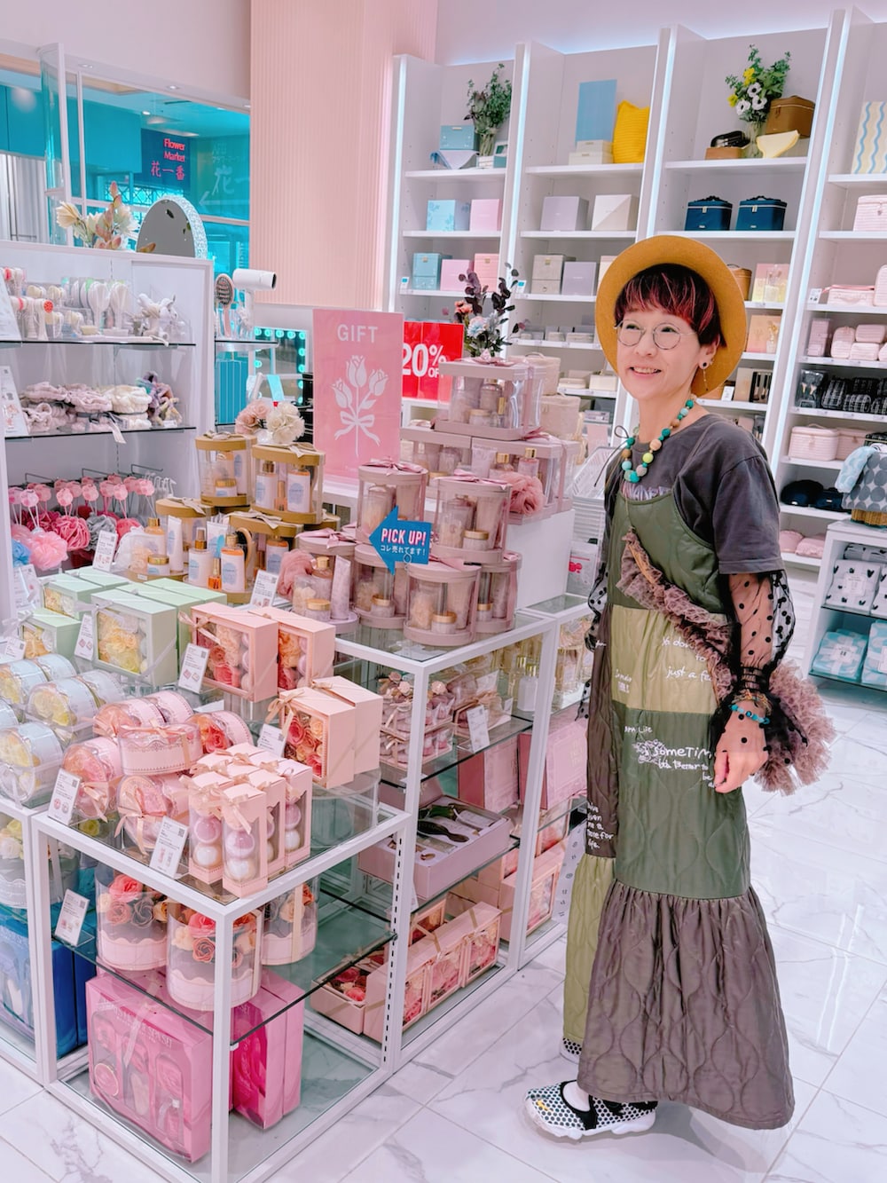 グリーン系のワンピース、ベージュ系のショルダーバッグ、ブラック系のアームカバーを着用したレディースの夏コーディネートの2枚目の写真