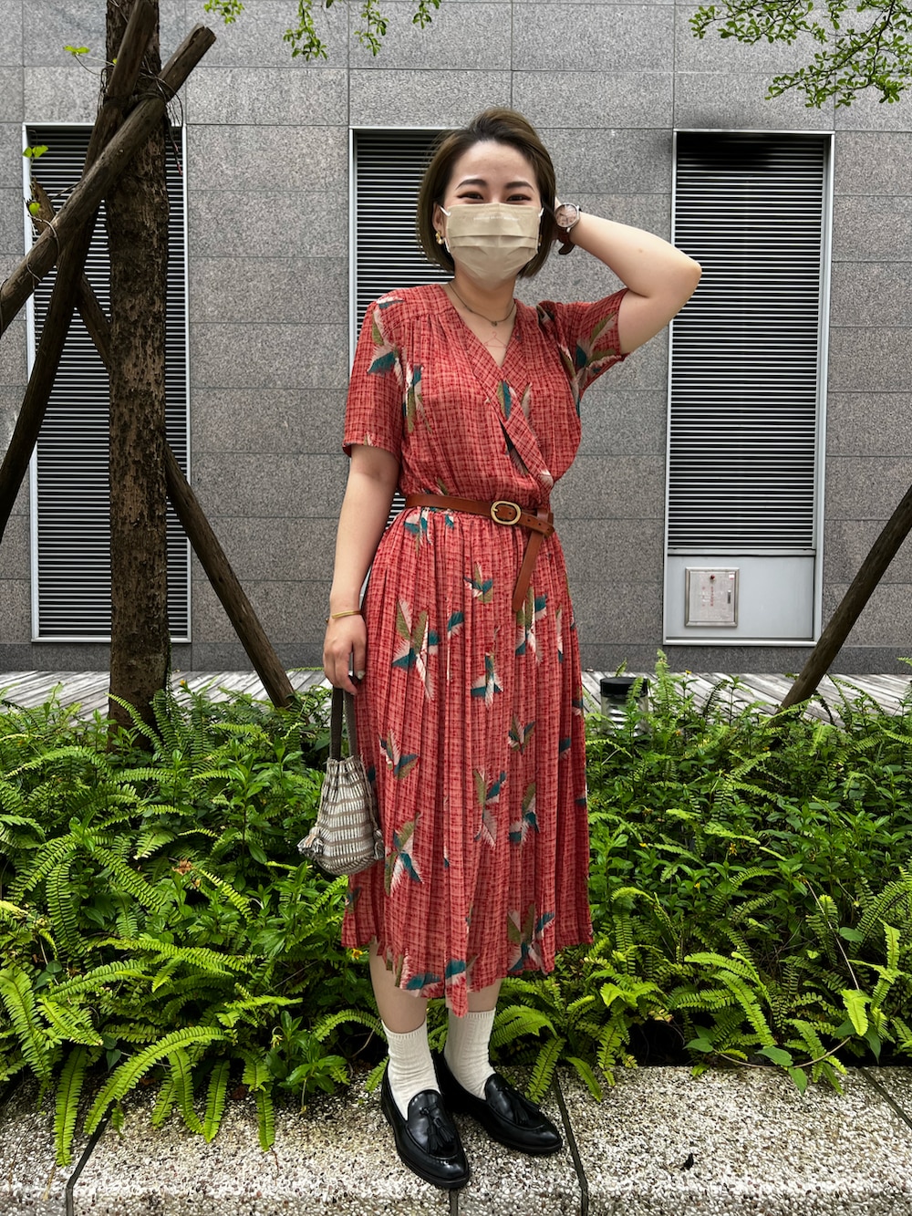 レッド系のワンピース、ブラック系のローファー、ブラウン系のベルトを着用したレディースの夏コーディネートの2枚目の写真