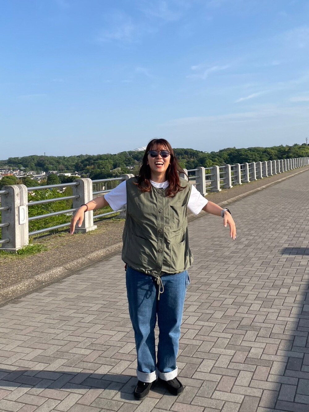 ブルー系のデニムパンツ、ブラック系のブーツ、ホワイト系のTシャツ/カットソーを着用したレディースの春コーディネートの2枚目の写真