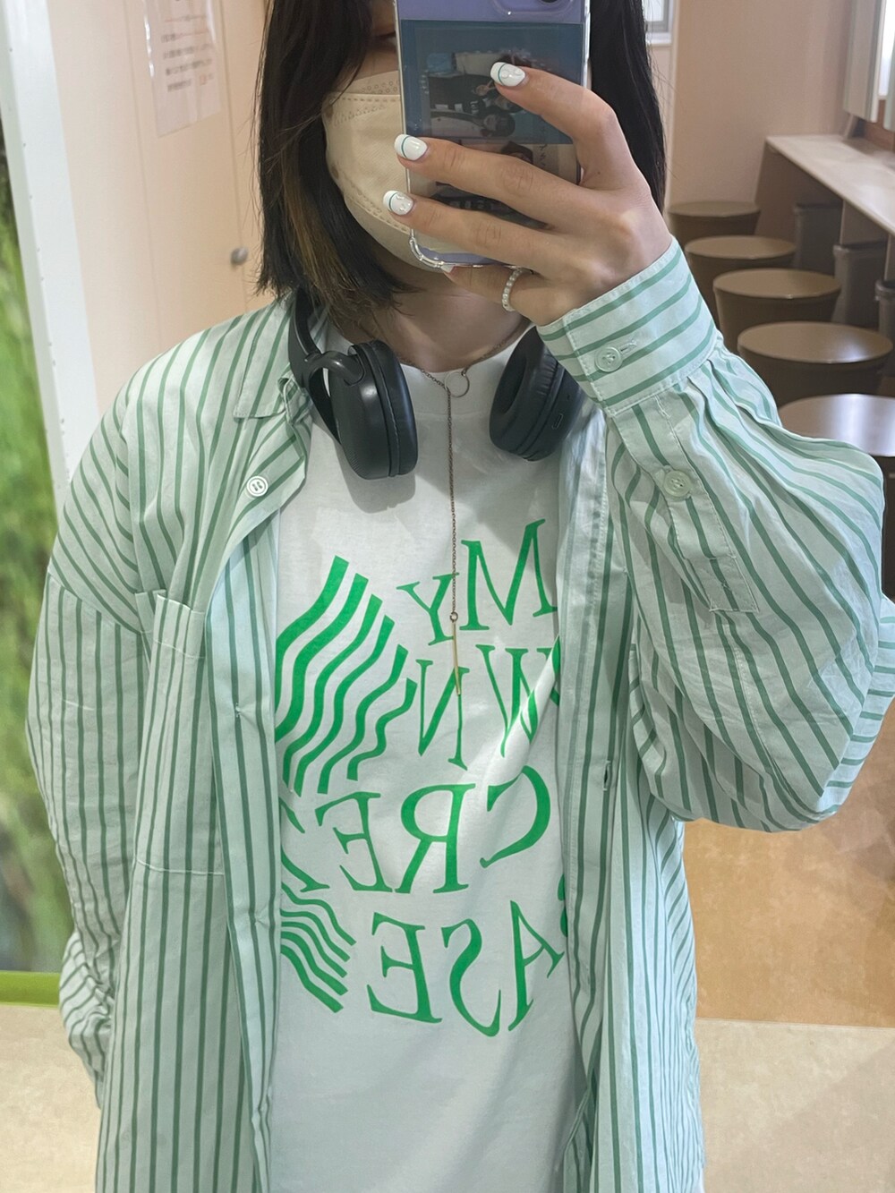 ホワイト系のTシャツ/カットソー、グリーン系のシャツ/ブラウス、ブルー系のデニムパンツを着用したレディースの春コーディネートの2枚目の写真