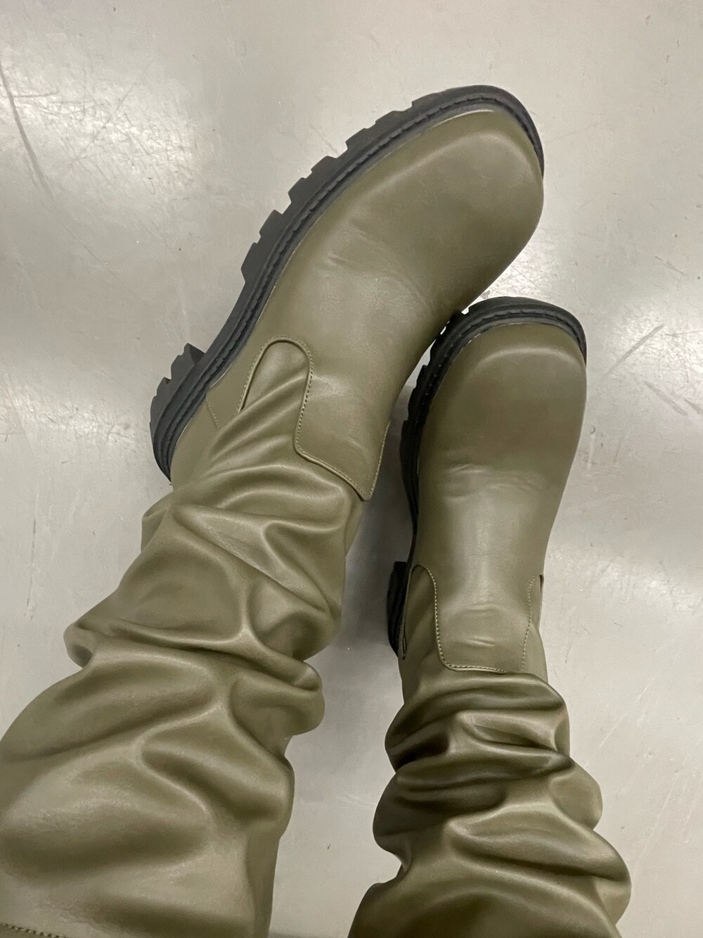 ホワイト系のミリタリージャケット、ブラック系のスカート、グリーン系のブーツを着用したレディースの冬コーディネートの3枚目の写真