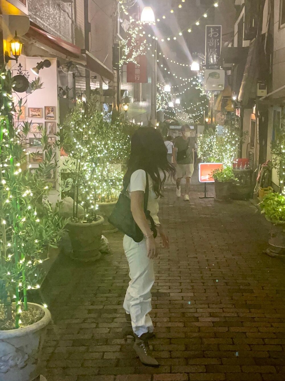 ホワイト系のTシャツ/カットソー、グレー系のデニムパンツ、ブラウン系のブーツを着用したレディースの秋コーディネートの2枚目の写真