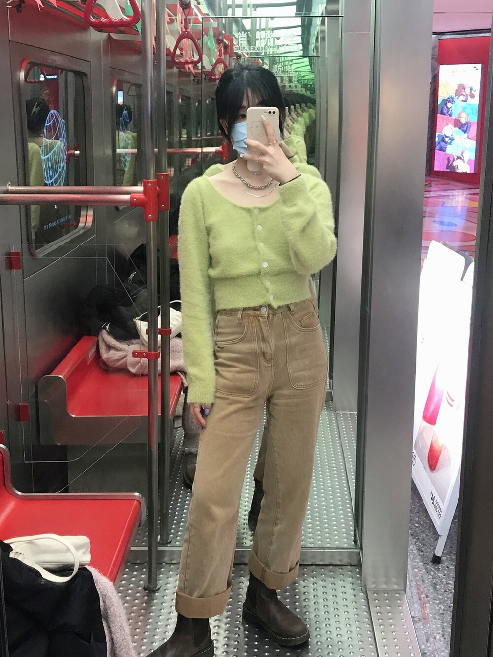 グリーン系のニット/セーター、ブラウン系のチノパンツを着用したレディースの秋コーディネートの2枚目の写真