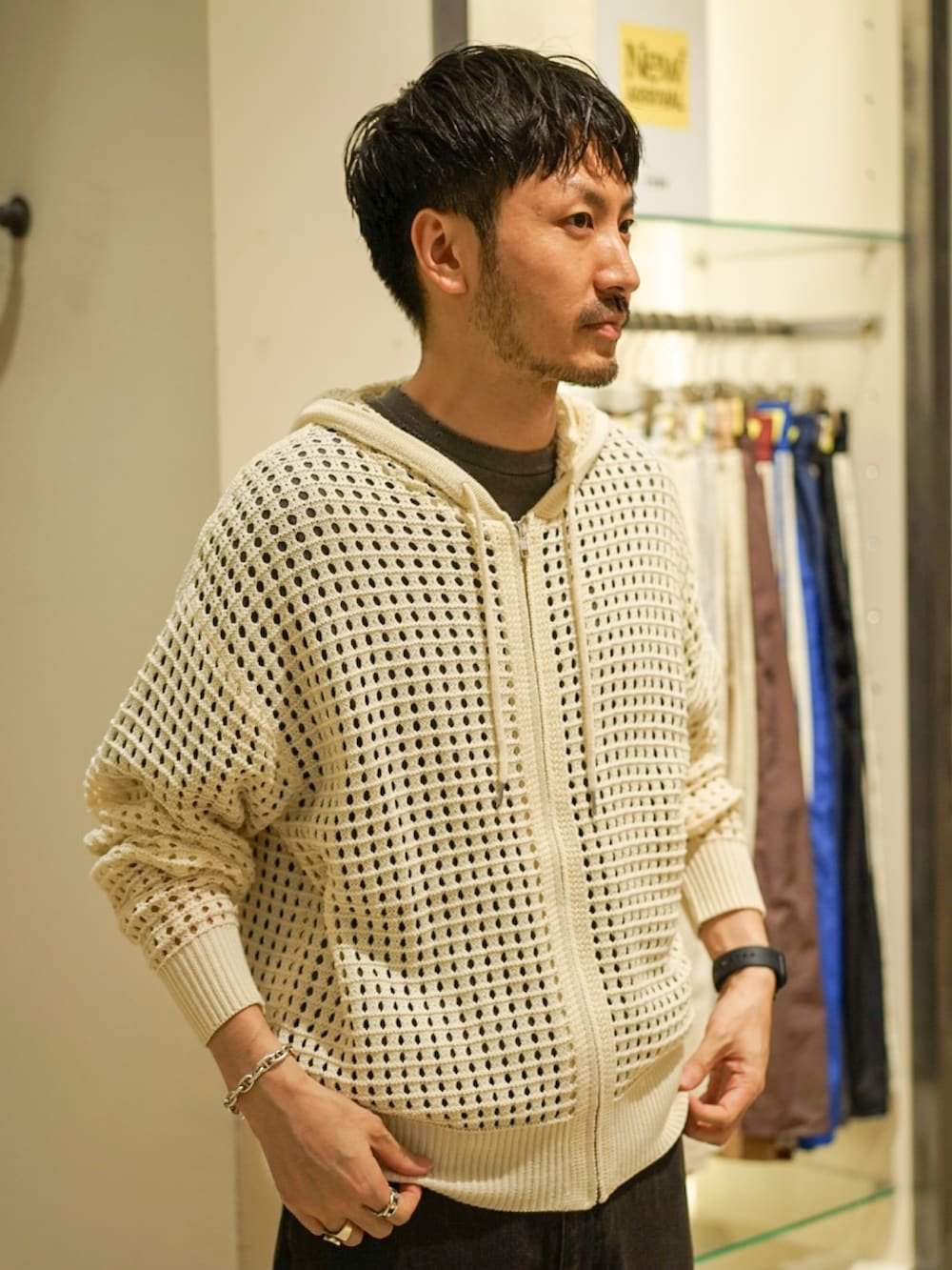 ホワイト系のパーカー、ブラック系のデニムパンツ、ブラック系のサンダルを着用したメンズの秋コーディネートの3枚目の写真