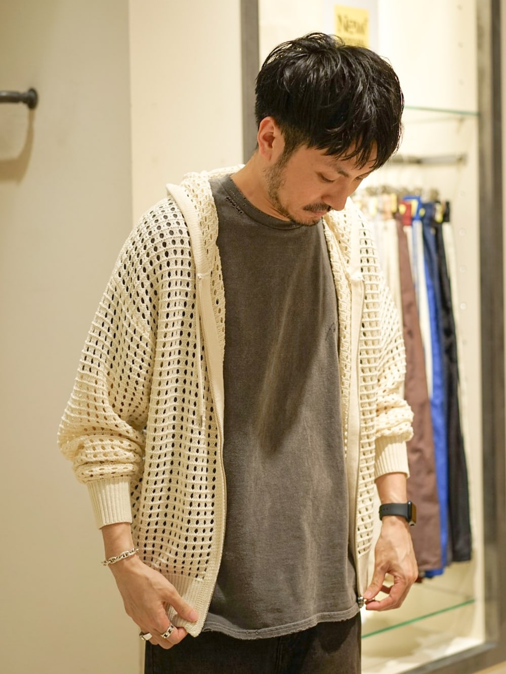 ホワイト系のパーカー、ブラック系のデニムパンツ、ブラック系のサンダルを着用したメンズの秋コーディネートの2枚目の写真