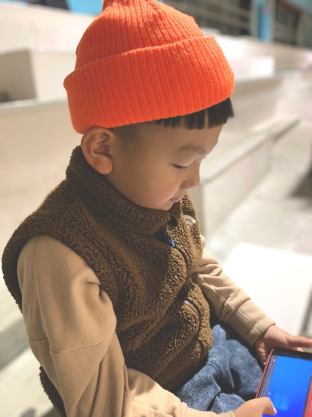 ブラウン系のブルゾン、ベージュ系のスウェット、ブルー系のパンツを着用したキッズの秋コーディネートの2枚目の写真