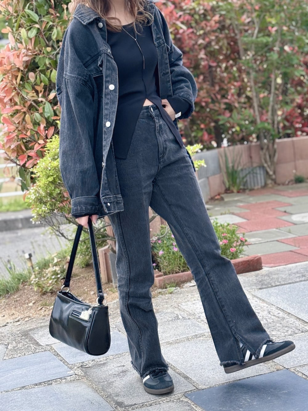 ブラック系のデニムジャケット、ブラック系のTシャツ/カットソー、ブラック系のデニムパンツを着用したレディースの春コーディネートの2枚目の写真