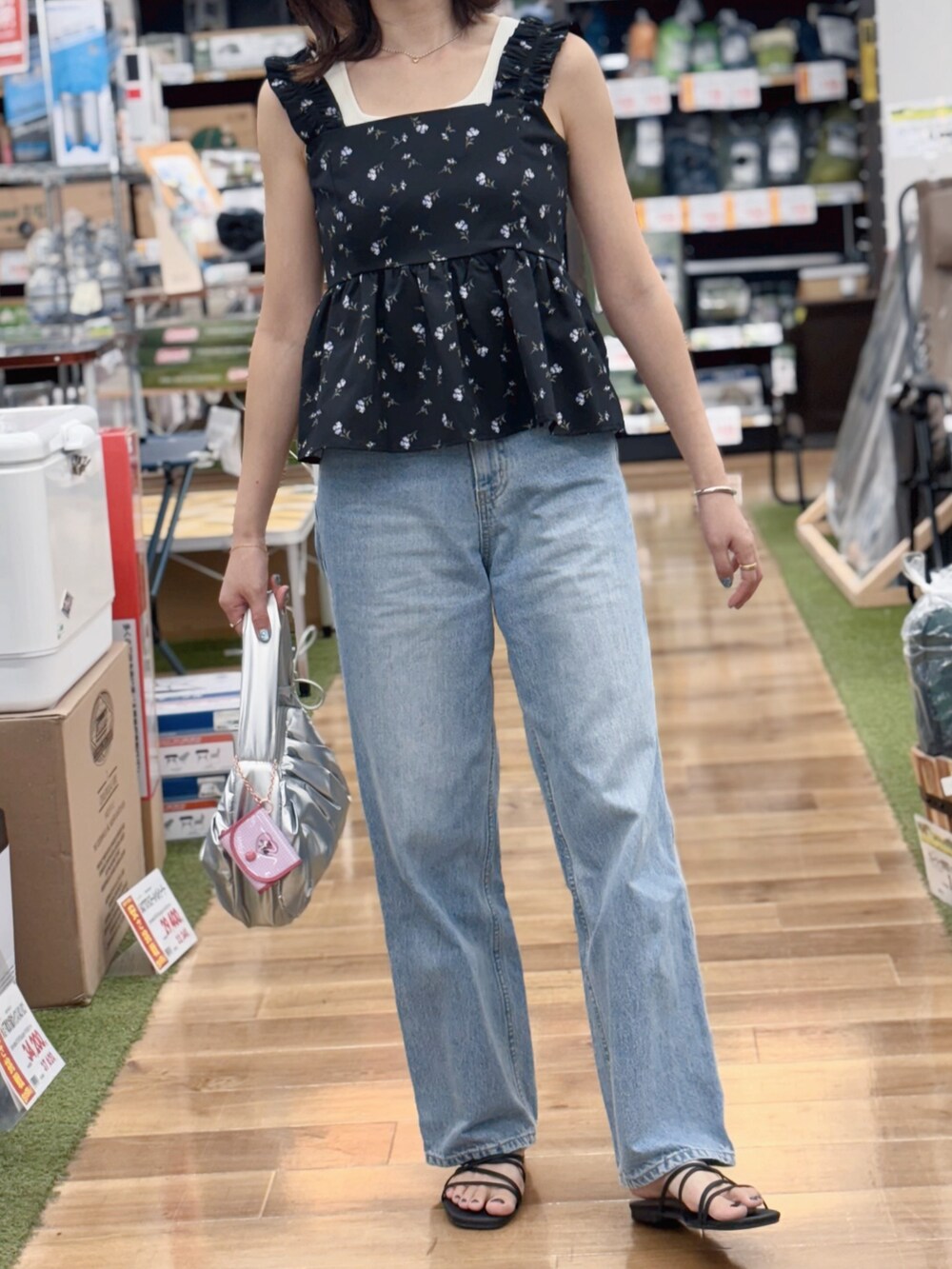 ブラック系のキャミソール、ブルー系のデニムパンツ、シルバー系のハンドバッグを着用したレディースの夏コーディネートの2枚目の写真