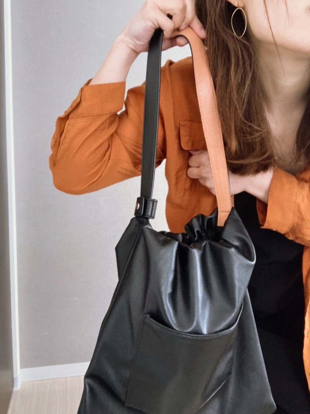 ブラック系のトートバッグ、ブラック系のオールインワン・サロペット、シルバー系のシューズを着用したレディースの春コーディネートの2枚目の写真