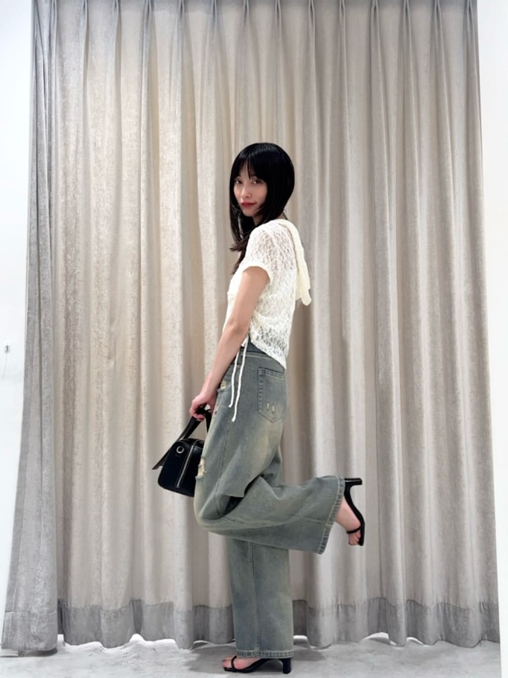 ホワイト系のパーカー、ブルー系のデニムパンツ、シルバー系のサンダルを着用したレディースの夏コーディネートの4枚目の写真