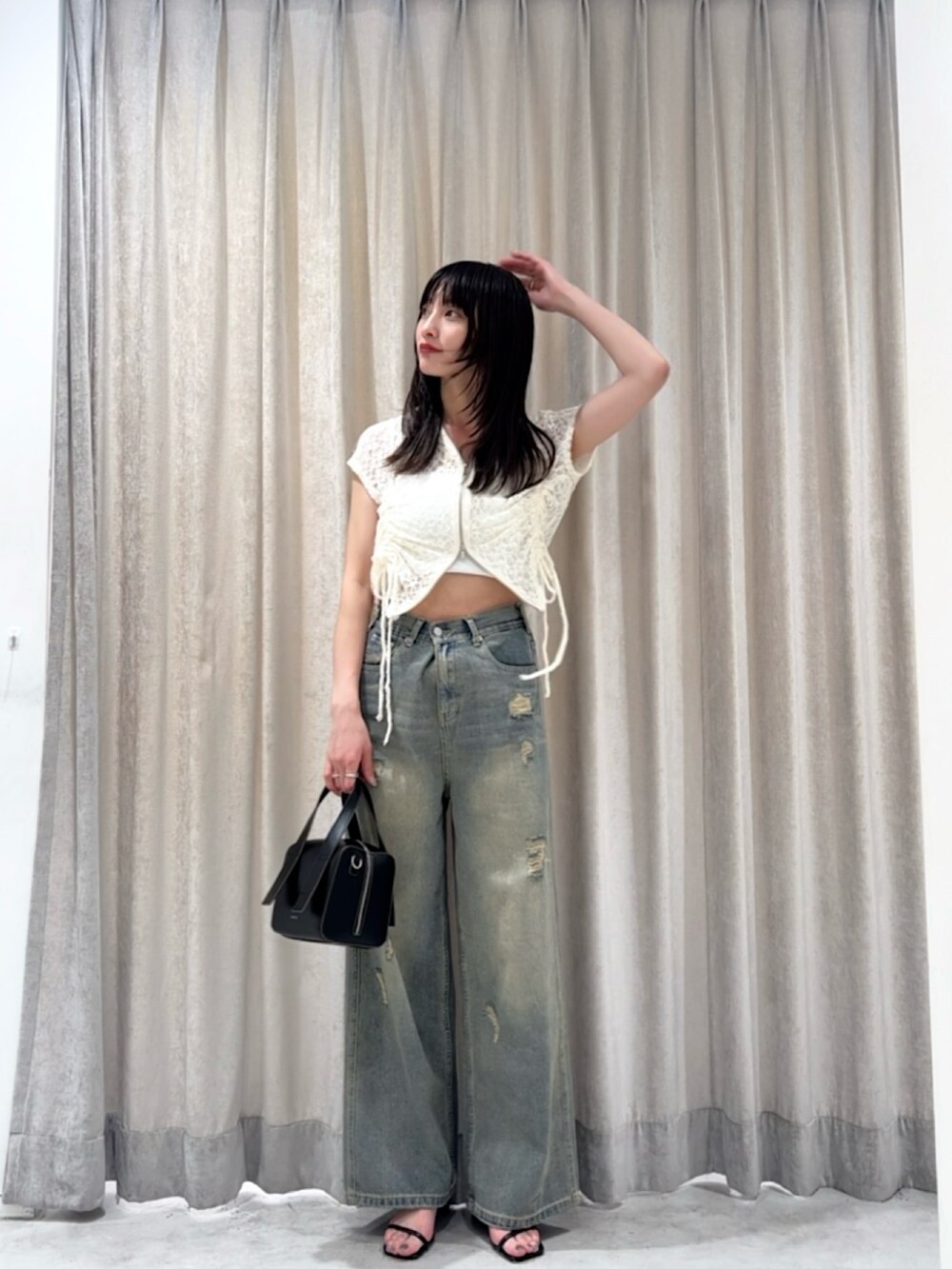 ホワイト系のパーカー、ブルー系のデニムパンツ、シルバー系のサンダルを着用したレディースの夏コーディネートの3枚目の写真