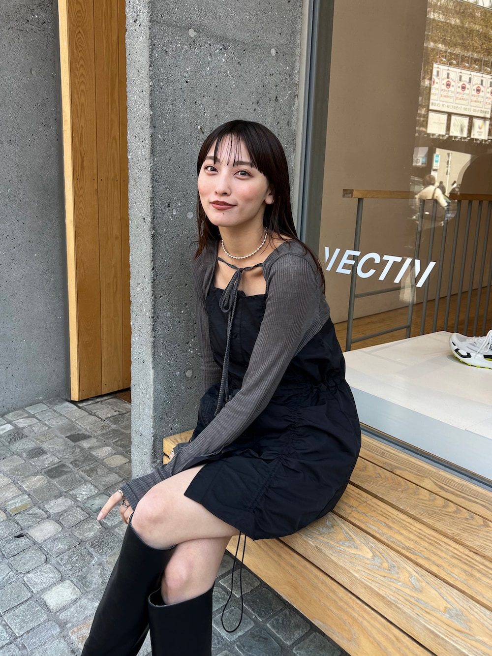 ブラック系のワンピースを着用したレディースの春コーディネートの2枚目の写真