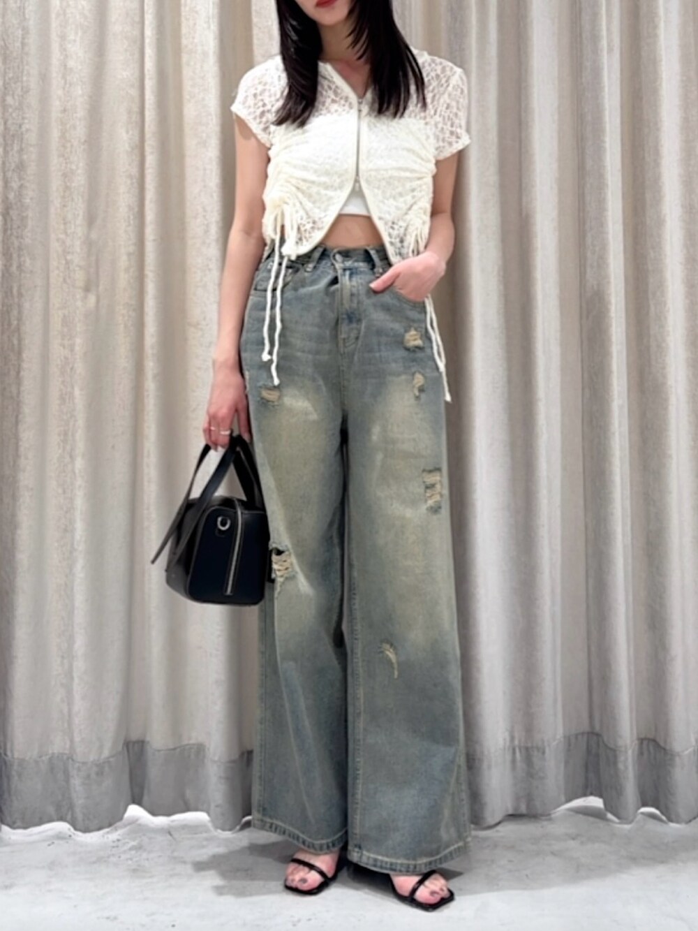 ホワイト系のパーカー、ブルー系のデニムパンツ、シルバー系のサンダルを着用したレディースの夏コーディネートの5枚目の写真