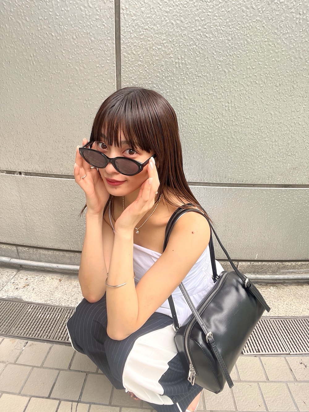 ホワイト系のシャツ/ブラウス、シルバー系のサンダルを着用したレディースの春コーディネートの3枚目の写真