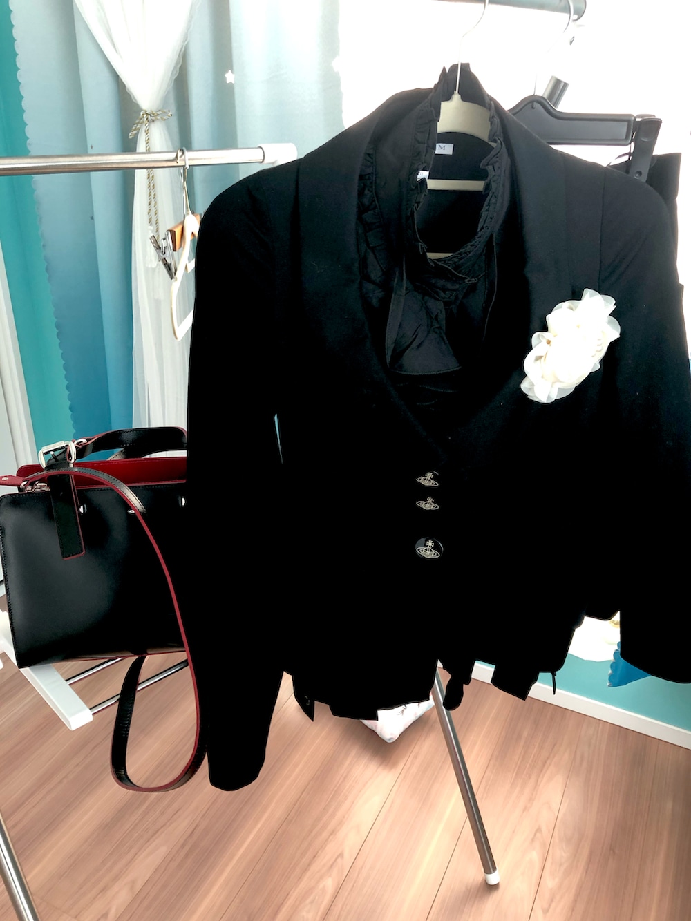 ブラック系のショルダーバッグ、ブラック系のスーツジャケット、ブラック系のスーツスカートを着用したレディースの冬コーディネートの2枚目の写真