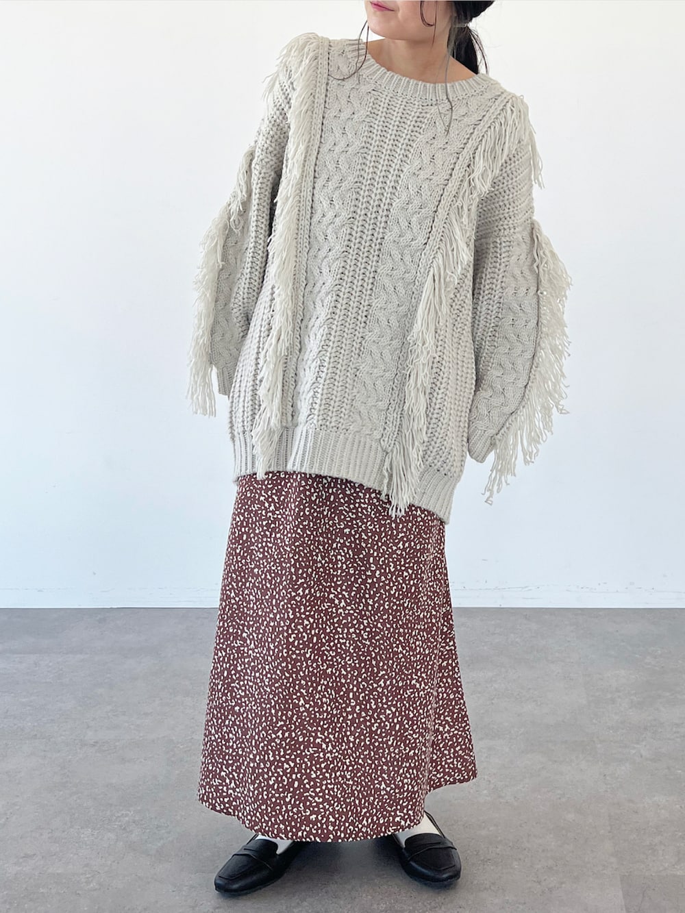 ベージュ系のニット/セーター、ブラウン系のスカートを着用したレディースの秋コーディネートの2枚目の写真