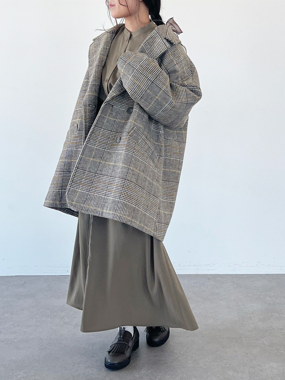 その他のその他アウター、グリーン系のワンピース、ブラウン系のヘアゴムを着用したレディースの秋コーディネートの2枚目の写真