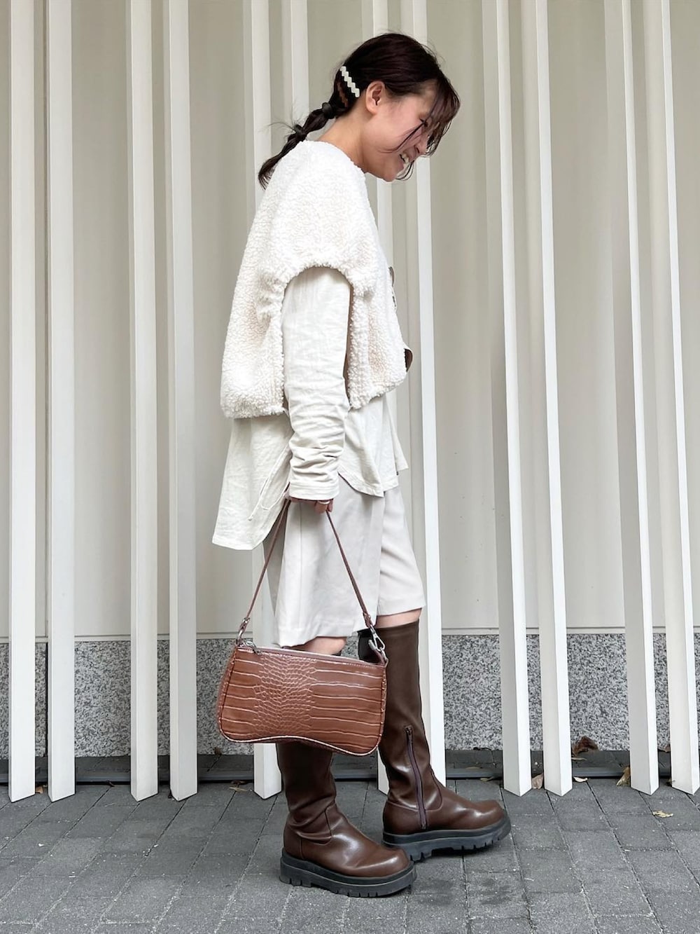 ホワイト系のブルゾン、グレー系のTシャツ/カットソー、ブラウン系のブーツを着用したレディースの秋コーディネートの3枚目の写真