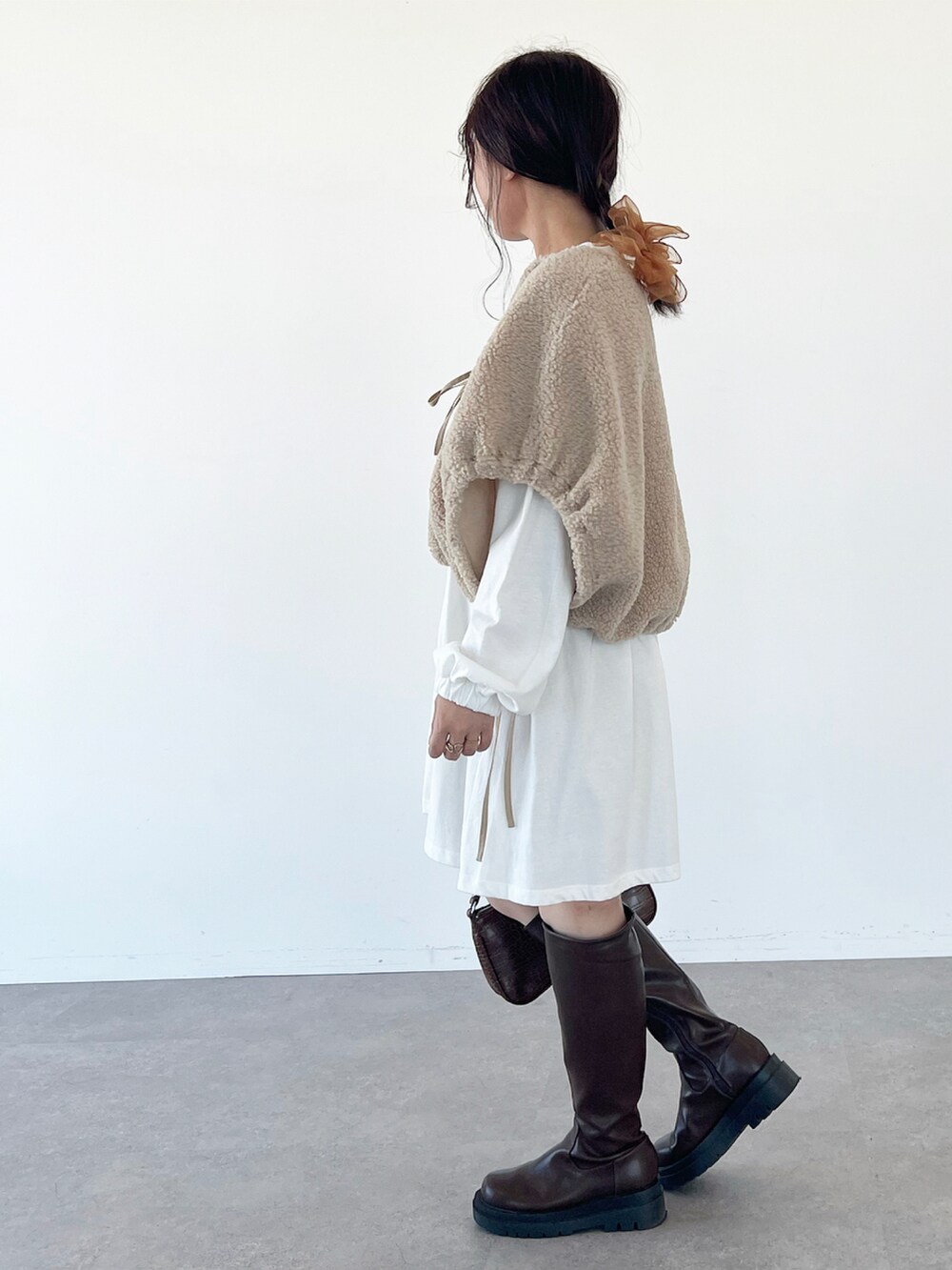 ブラウン系のブーツ、ホワイト系のTシャツ/カットソー、ベージュ系のブルゾンを着用したレディースの秋コーディネートの2枚目の写真