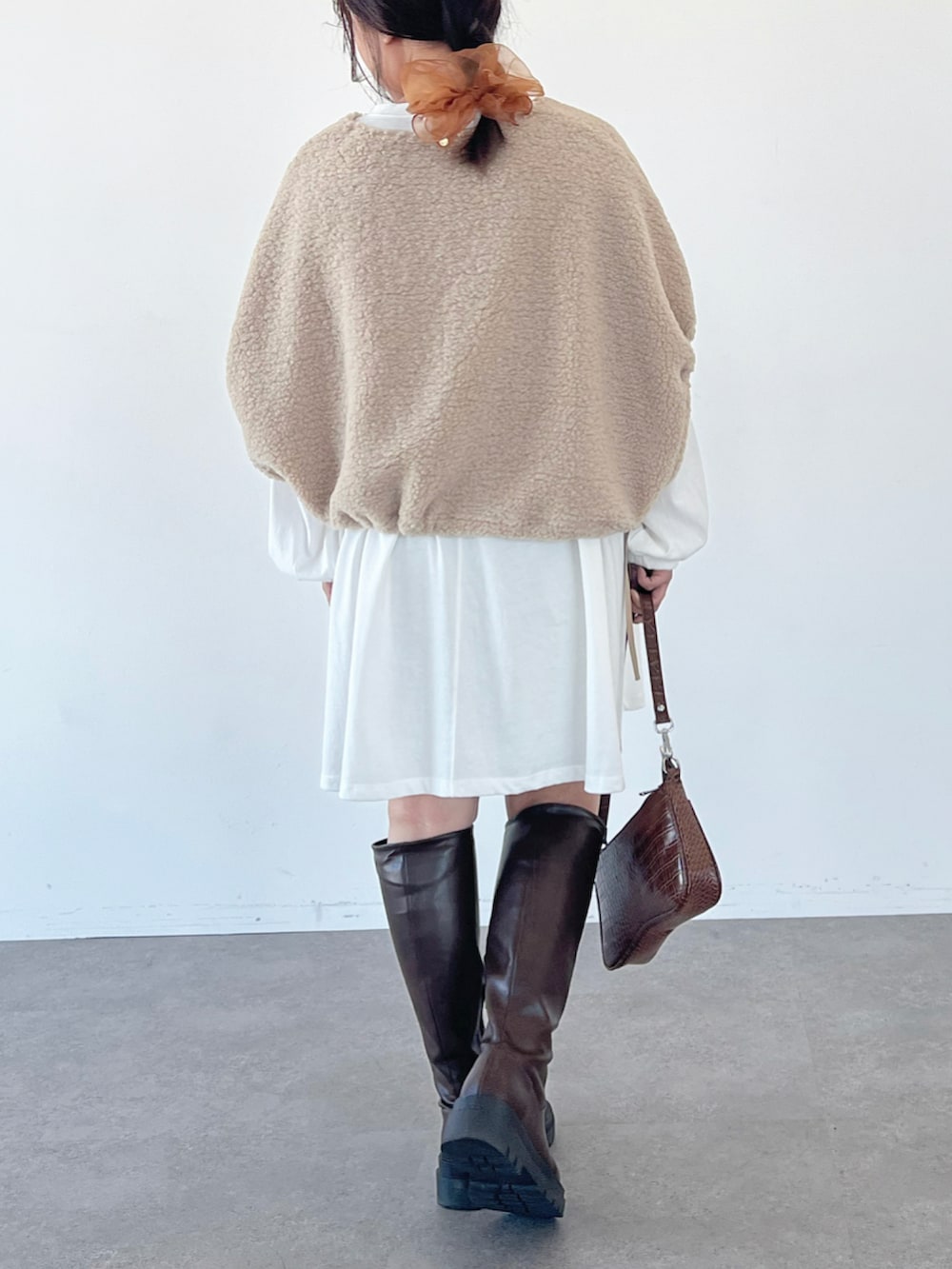 ブラウン系のブーツ、ホワイト系のTシャツ/カットソー、ベージュ系のブルゾンを着用したレディースの秋コーディネートの3枚目の写真