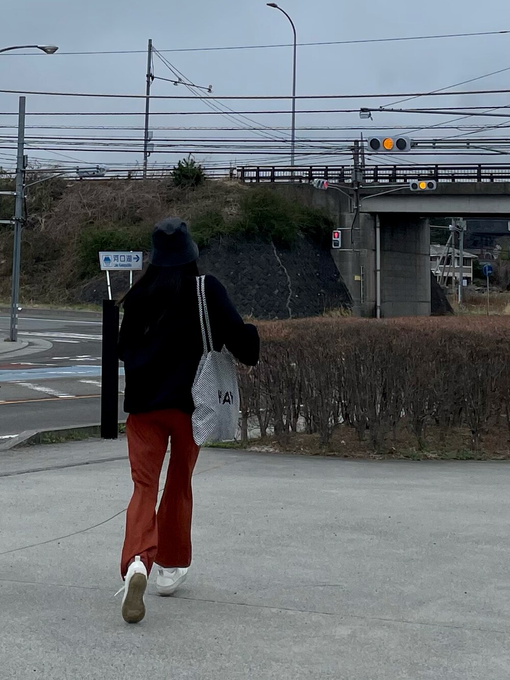 ブラック系のスウェット、オレンジ系のその他パンツを着用したレディースの春コーディネートの2枚目の写真