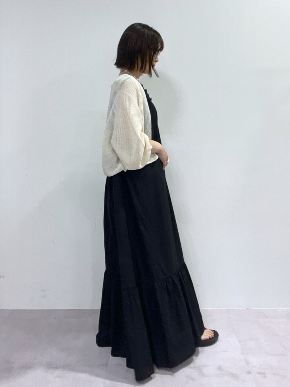 ホワイト系のカーディガン/ボレロ、ブラック系のワンピース、ブラック系のタンクトップを着用したレディースの春コーディネートの2枚目の写真