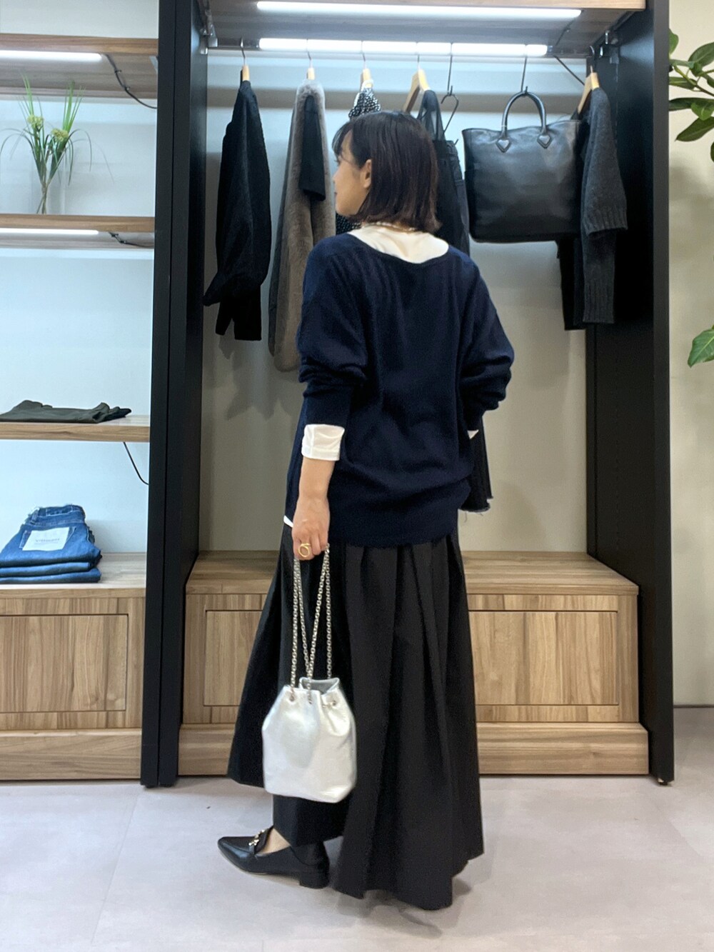 ブルー系のニット/セーター、ホワイト系のTシャツ/カットソー、ブラック系のスカートを着用したレディースの秋コーディネートの3枚目の写真