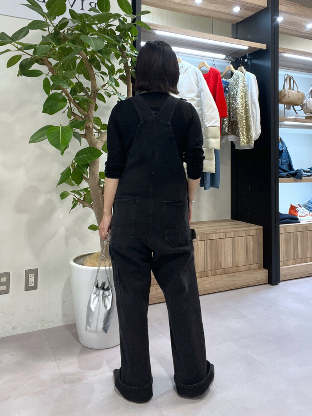 シルバー系のショルダーバッグ、ブラック系のサロペット/オーバーオール、ブラック系のTシャツ/カットソーを着用したレディースの秋コーディネートの3枚目の写真