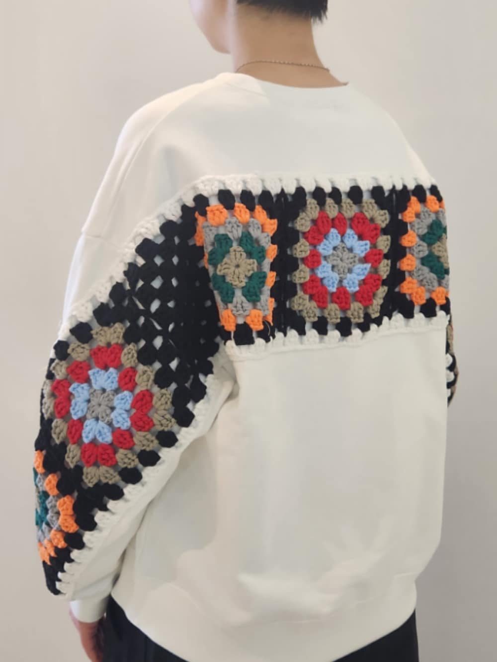 ホワイト系のニット/セーター、ブラック系のその他パンツを着用したレディースの冬コーディネートの2枚目の写真