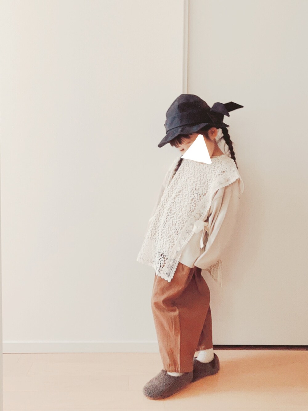 ホワイト系のベスト、ベージュ系のTシャツ/カットソー、ブラウン系のパンツを着用したキッズの冬コーディネートの3枚目の写真