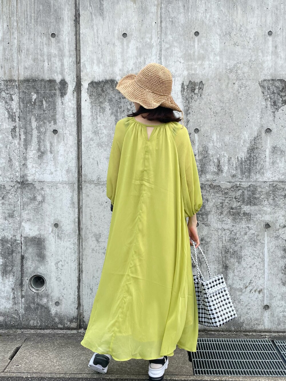 グリーン系のワンピース、その他のショルダーバッグ、ベージュ系のハットを着用したレディースの春コーディネートの3枚目の写真