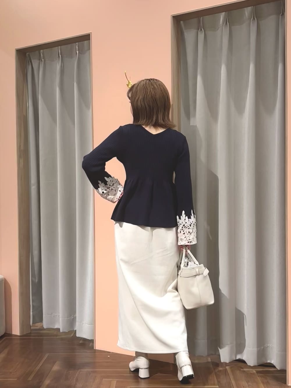 ブルー系のニット/セーター、ホワイト系のブーツ、ホワイト系のショルダーバッグを着用したレディースの冬コーディネートの2枚目の写真