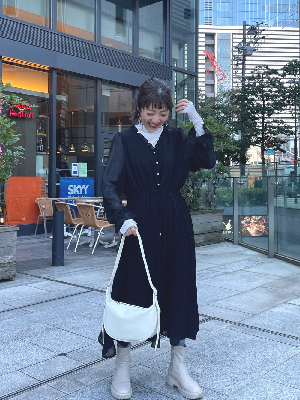 ブラック系のワンピース、ホワイト系のデニムジャケットを着用したレディースの冬コーディネートの2枚目の写真