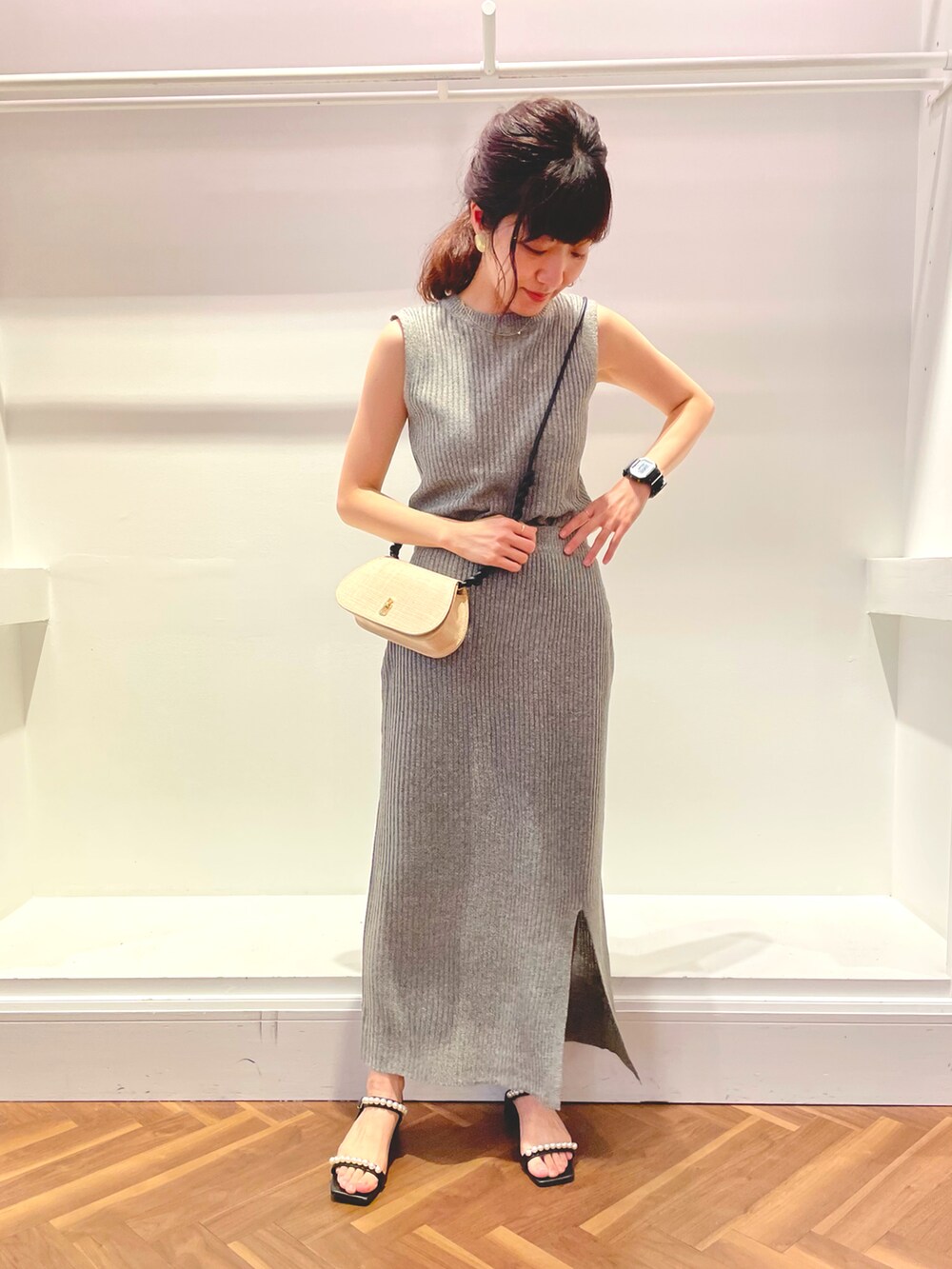 グレー系のニット/セーター、グレー系のスカート、ブラック系のサンダルを着用したレディースの春コーディネートの2枚目の写真