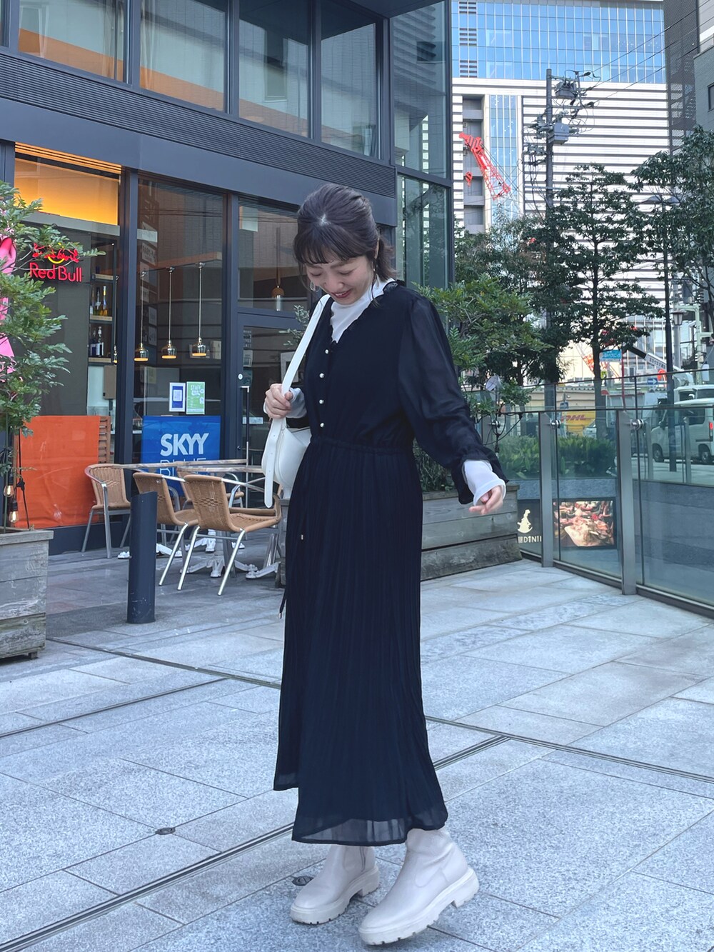 ブラック系のワンピース、ホワイト系のデニムジャケットを着用したレディースの冬コーディネートの3枚目の写真