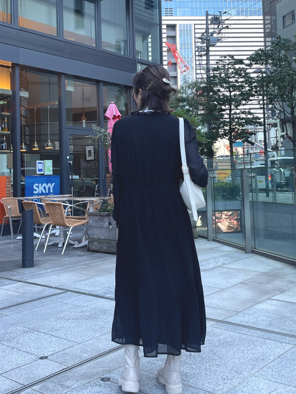 ブラック系のワンピース、ホワイト系のデニムジャケットを着用したレディースの冬コーディネートの4枚目の写真