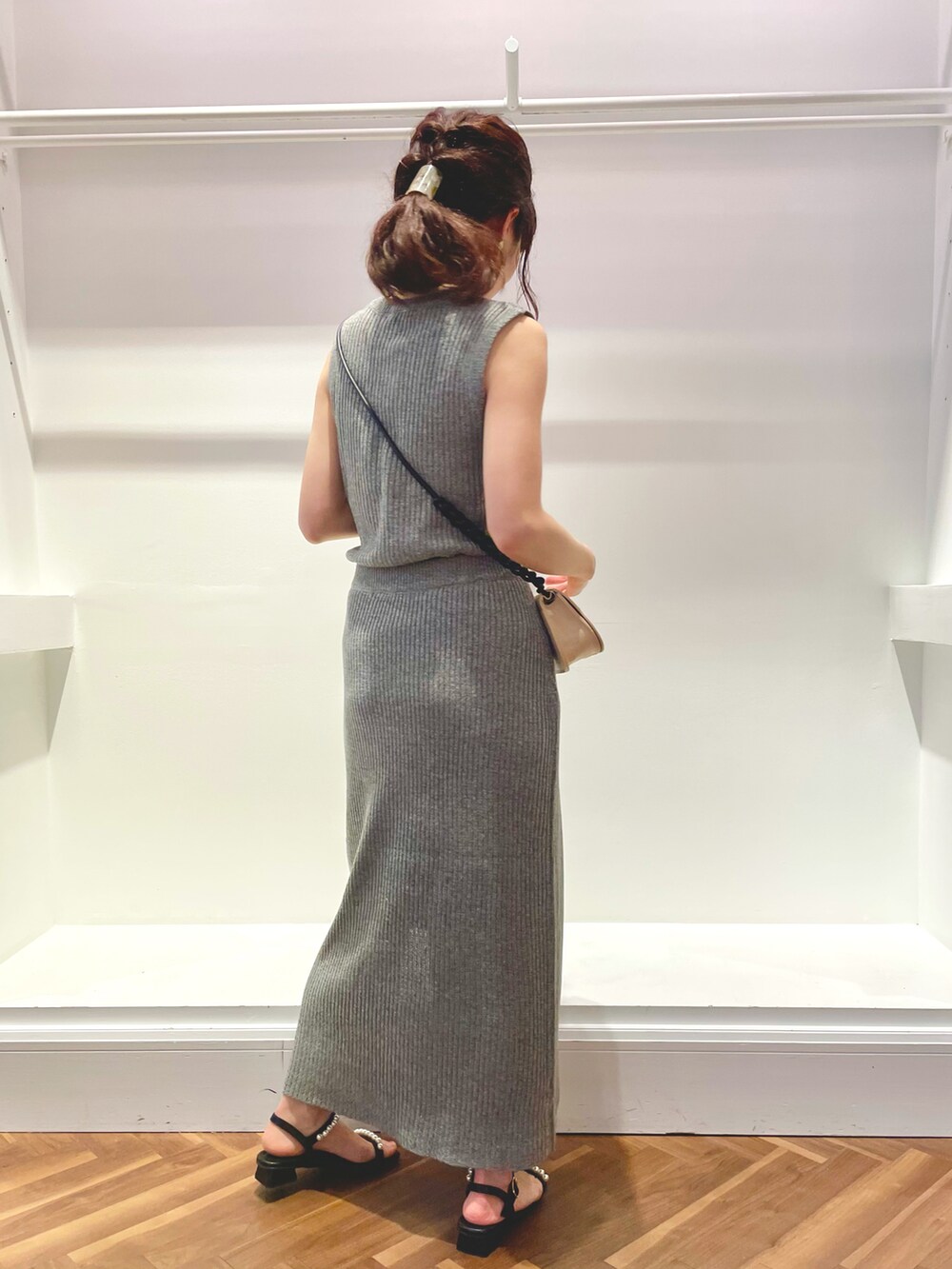 グレー系のニット/セーター、グレー系のスカート、ブラック系のサンダルを着用したレディースの春コーディネートの4枚目の写真