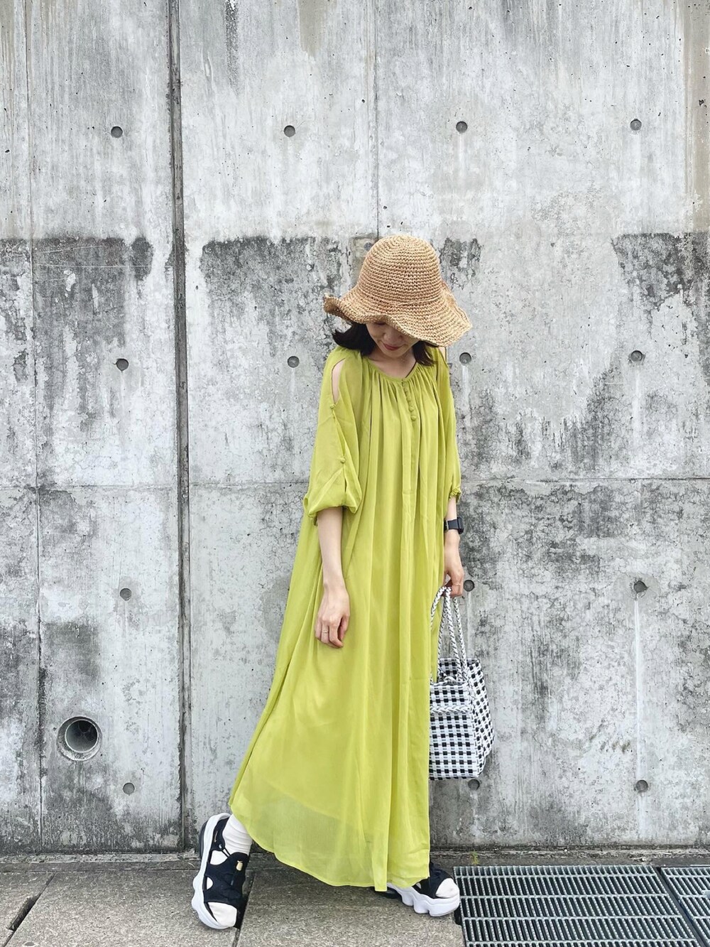 グリーン系のワンピース、その他のショルダーバッグ、ベージュ系のハットを着用したレディースの春コーディネートの2枚目の写真
